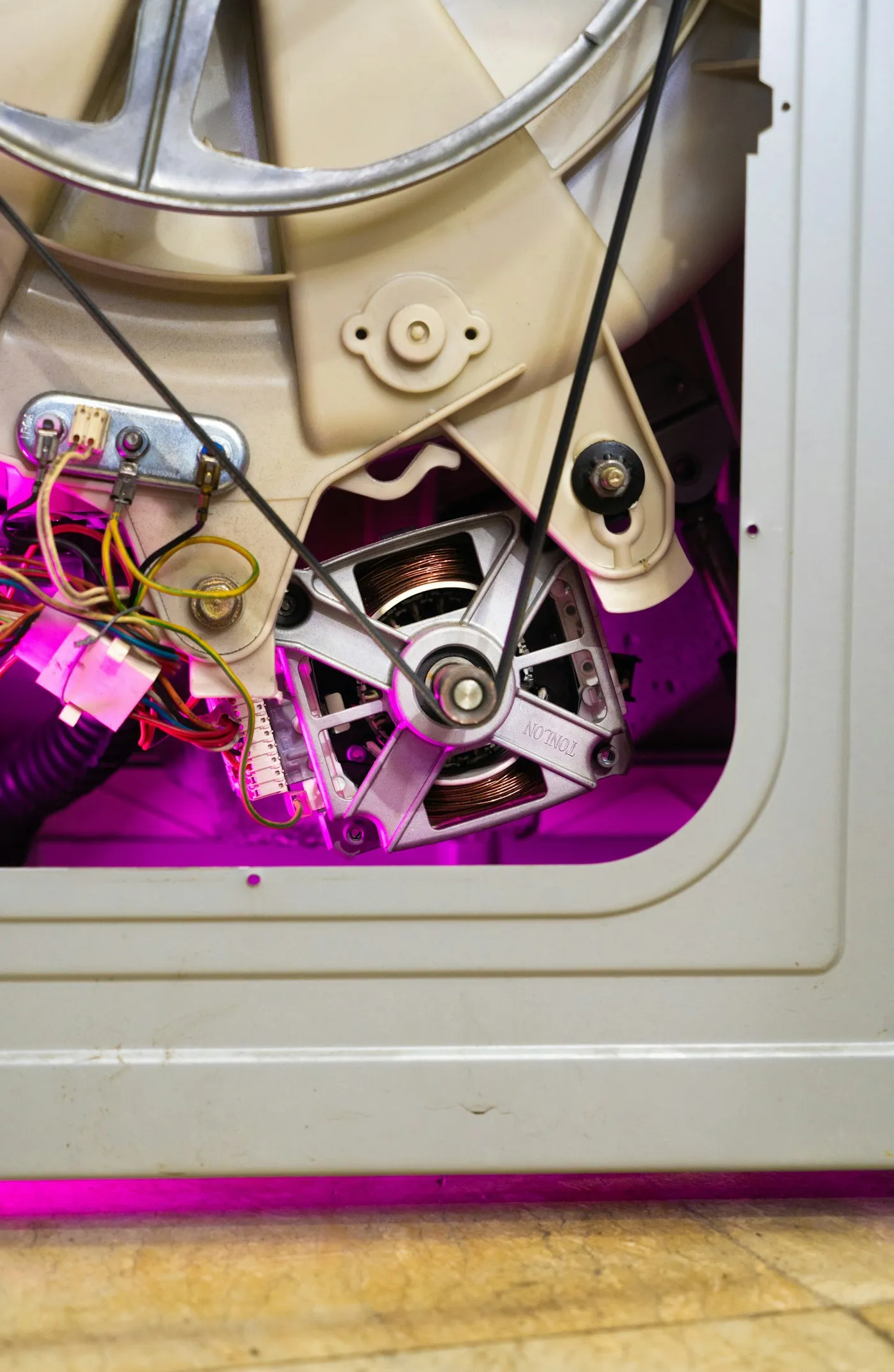 Engineer repairing a washing machine motor and belt