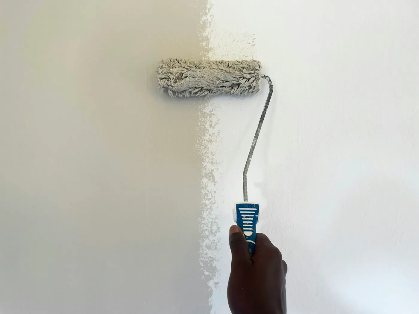 Decorator using a paint roller on an interior wall